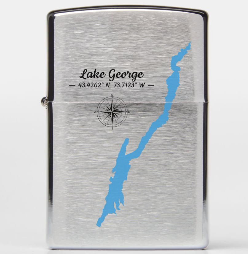 A brushed silver metal lighter featuring a blue map outline of Lake George, New York, with the text 'Lake George' and coordinates printed on the front.